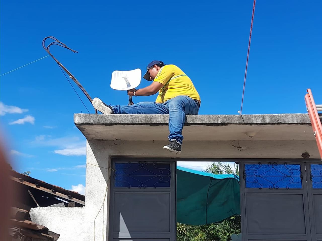 Tecnico instalando antena inalambrica sobre techo